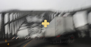 blurry image of NJ highway from inside of a car looking at bridge and 18-wheeler simulating a car accident